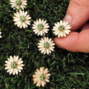 Orecchini margherita dorati e smaltati con capolino emisferico formato da piccoli smeraldi naturali, sei per ciascun fiore.  OH0933