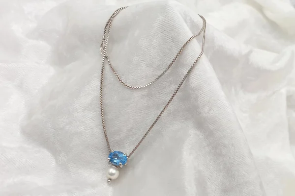 Girocollo con pendente di topazio blu sfaccettato e perla. CA1385